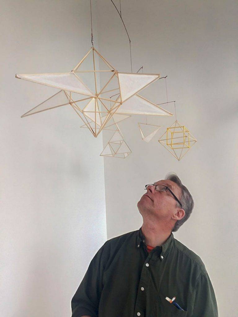Artscapes alumnus Roger Ralston standing next to his mobile Artscape installation in the Woolworth windows. Photo by Lisa Nappa.